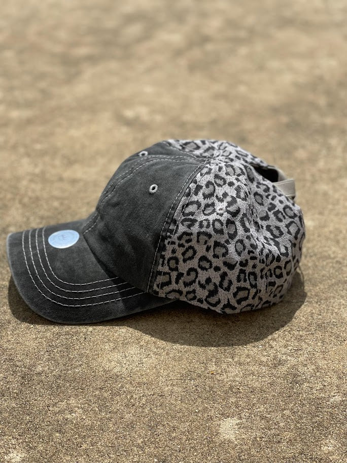 This cap has a distressed black front and a grey leopard back. The back has elastic crisscrossing bands and a adjustable Velcro back for a truly adjustable fit for your ponytails or buns. Side View 