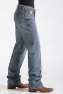 Right front of Cinch Medium Wash White Label jeans showing front and back pockets, fit to leg, and stack on boots.