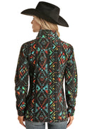 A woman wearing a turquoise aztec print fleece front zip jacket with princess seams and standing collar. Back view.