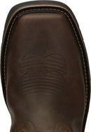 A toe view pair of Justin Men's 11" Steel Toe Driller work boots in rugged tan color with a square toe style and decorative stitching. 