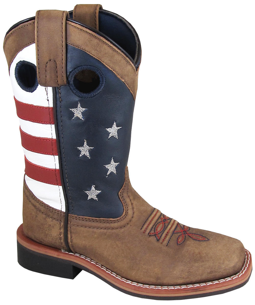 A youth square-toe boot with a light brown distressed foot and stars and stripes pattern on top, predominantly red, white, and blue, indicating an American flag design.
