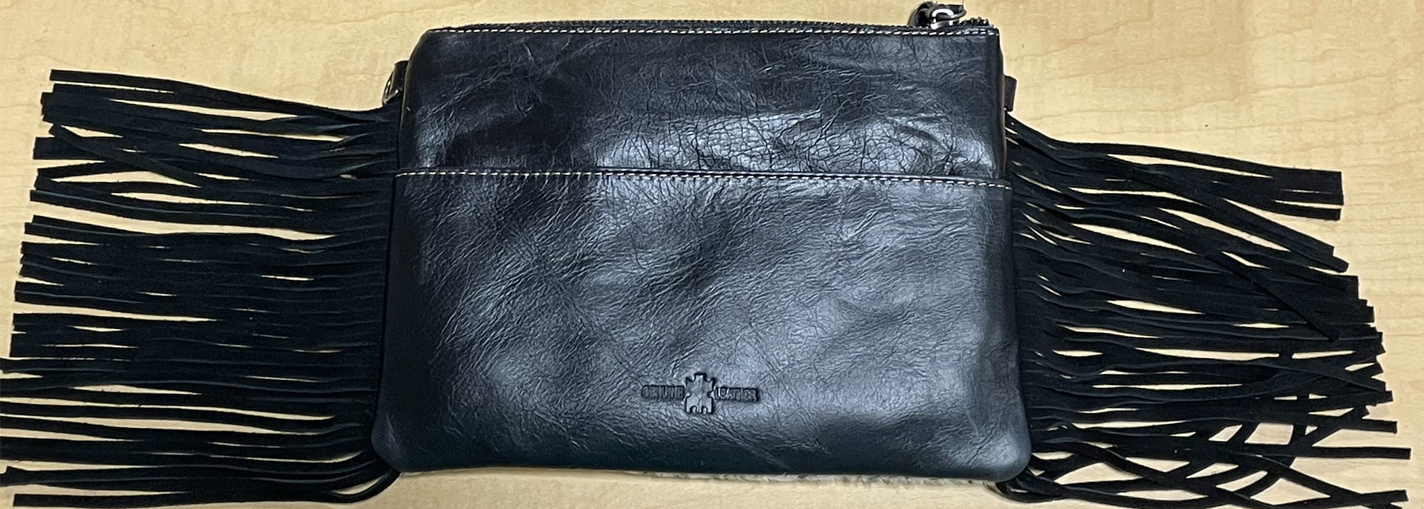 Black leather and crossbody bag with fringe leather sides. Rear View 
