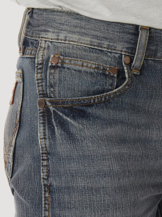 Closeup of front right pocket showing the front scoop pocket with the smaller coin pocket above, and copper rivets on the top corners on a man wearing Wrangler Retro slim fit straight leg jeans with a dark night wash. 