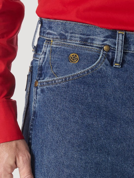 A close-up view of the front pocket of a Wrangler men's George Strait Cowboy Cut slim fit jeans showing the top rivets, the coin pocket with logo, and the larger scoop pocket.