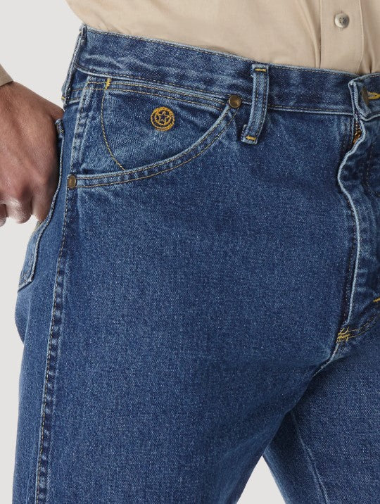 A close-up view of the front pocket of a Wrangler men's George Strait Cowboy Cut original fit jeans showing the top rivets, the coin pocket with logo, and the larger scoop pocket.