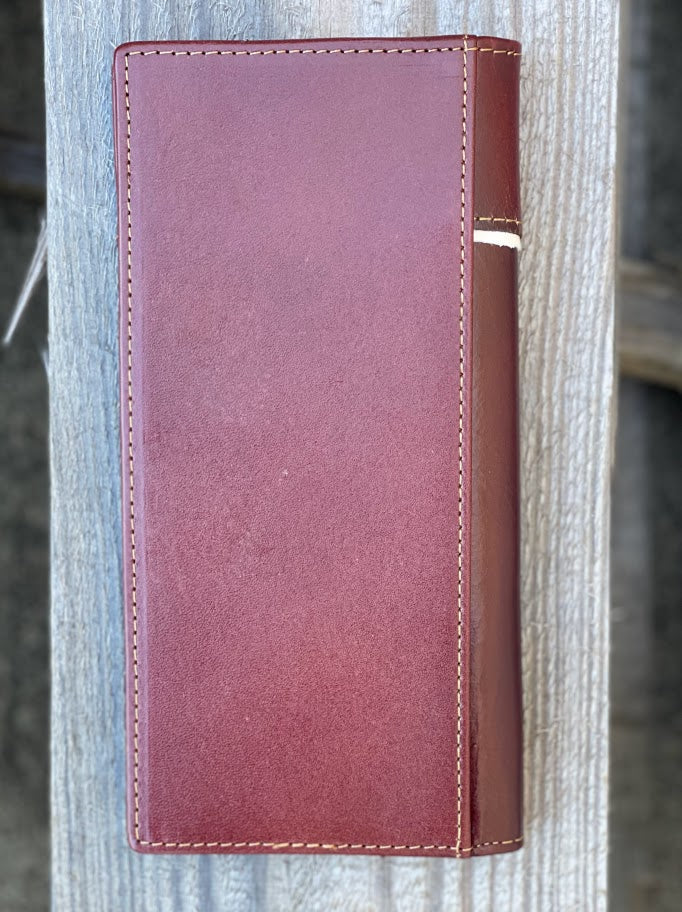 Brown leather tall wallet with a beige inlay featuring a embossed Praying Cowboy design.  Rear view