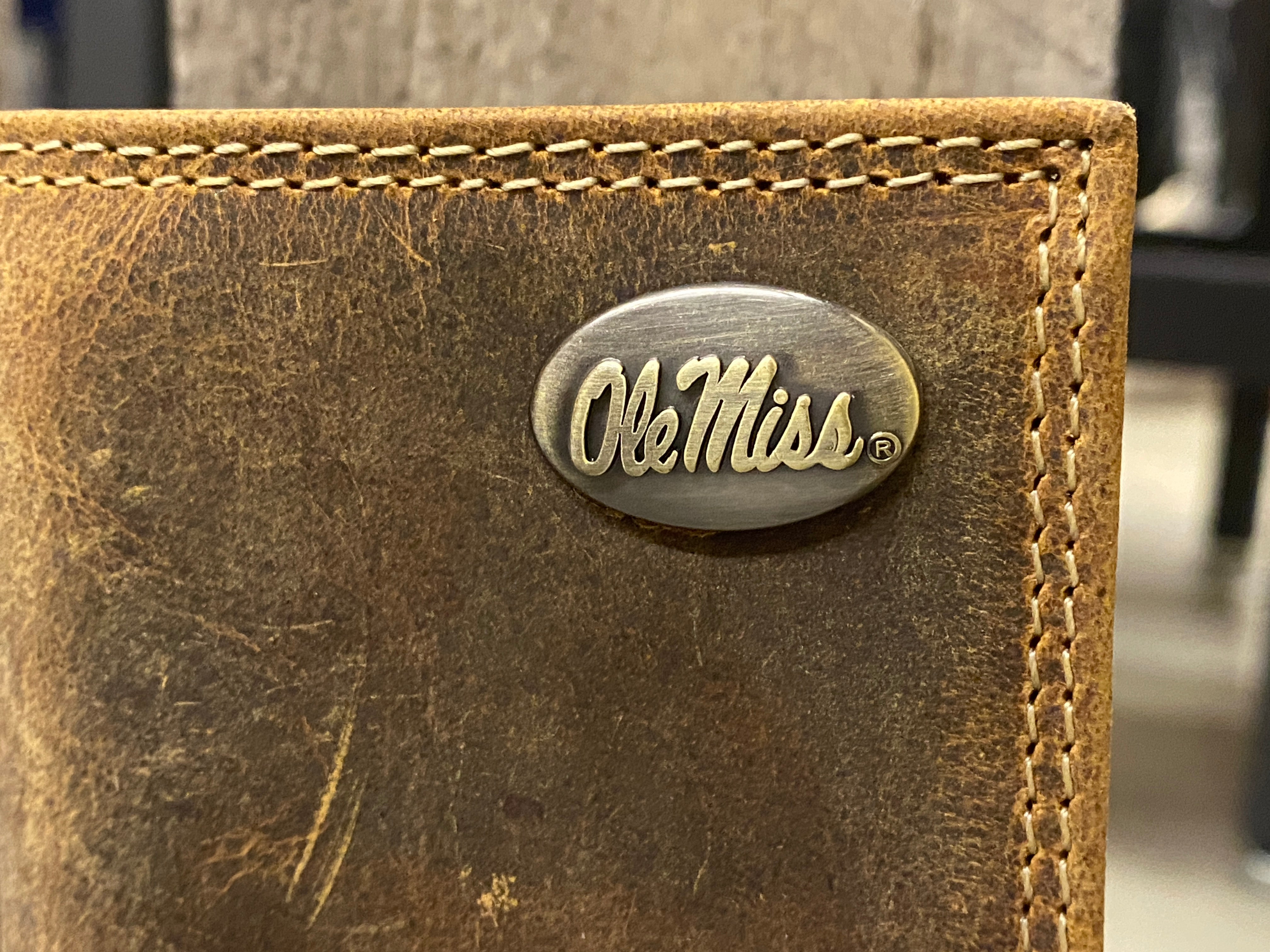 Zep Pro University of Mississippi Vintage Tan Leather Tri-fold Wallet. Front view closeup shows brass Ole Miss logo concho on upper right.