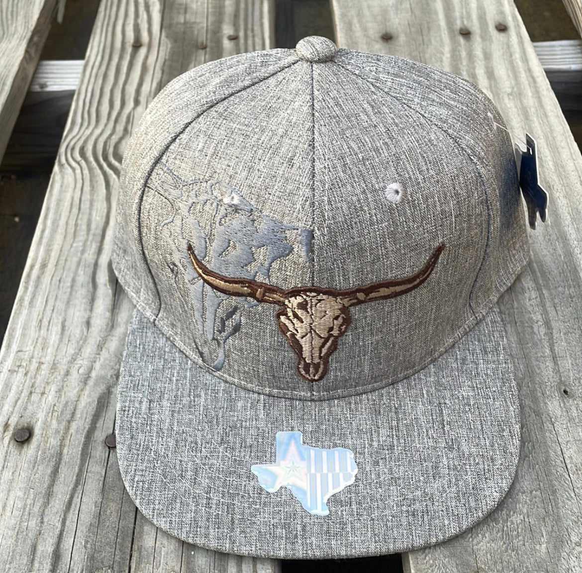 Heather Grey snapback cap with two longhorn steers embroidered on the front and a small on on the rear. Front View 