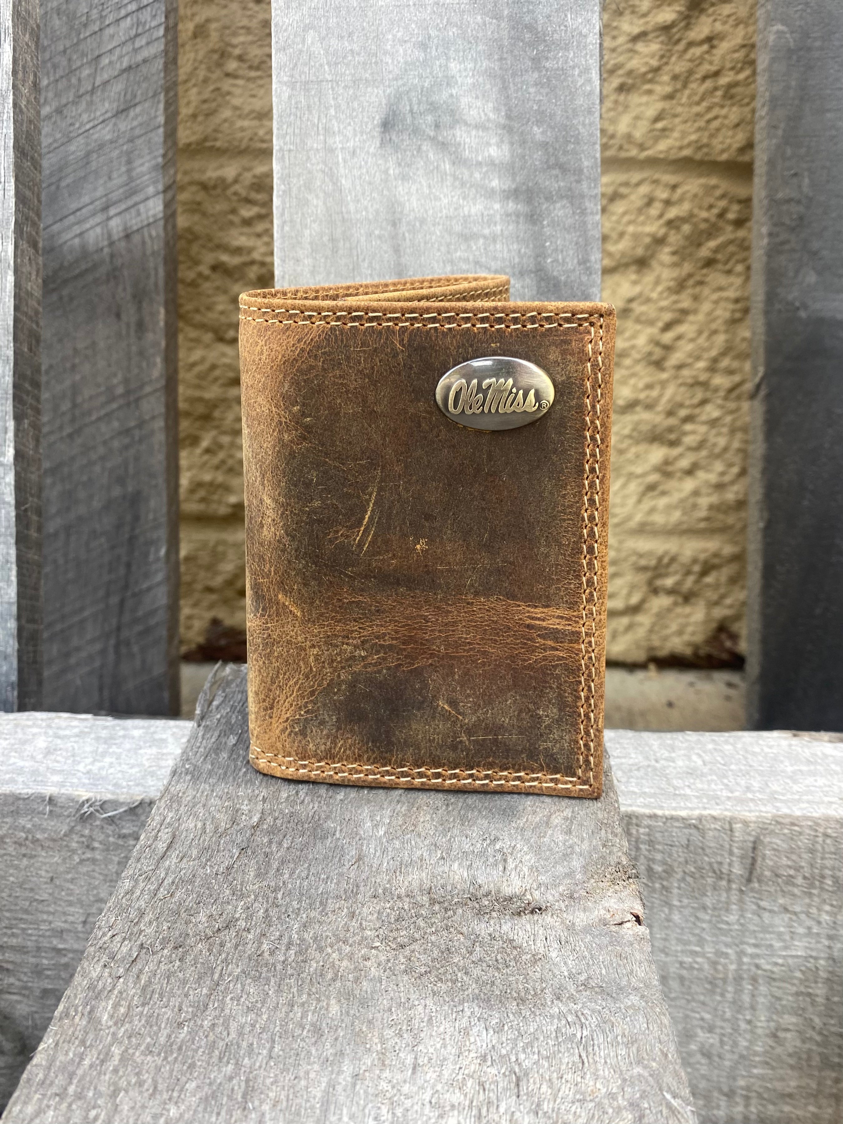 Zep Pro University of Mississippi Vintage Tan Leather Tri-fold Wallet. Front view shows Ole Miss brass concho on upper right corner.