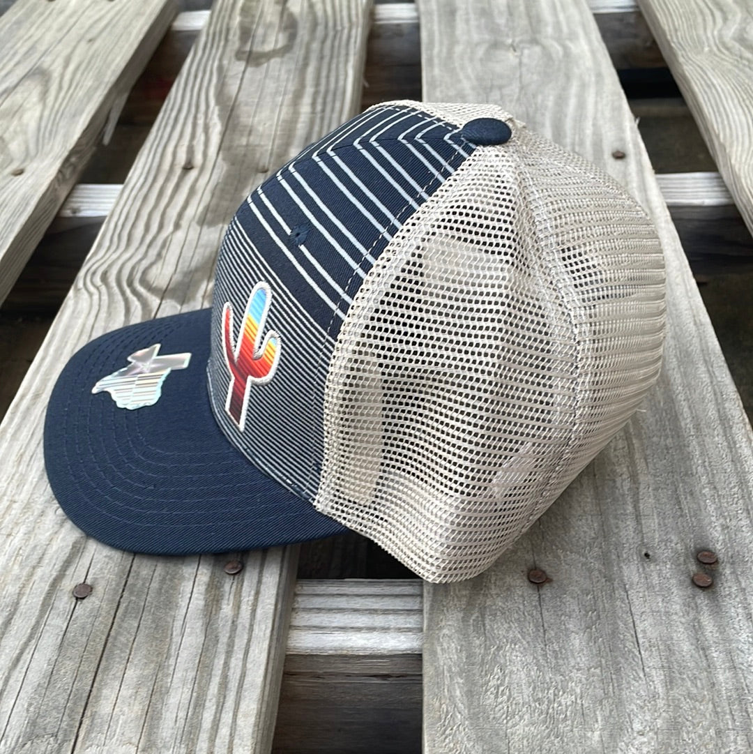 Navy and Grey trucker cap with a striped pattern featuring a cactus patch design on the front, solid Navy bill, Grey mesh back. Side view 