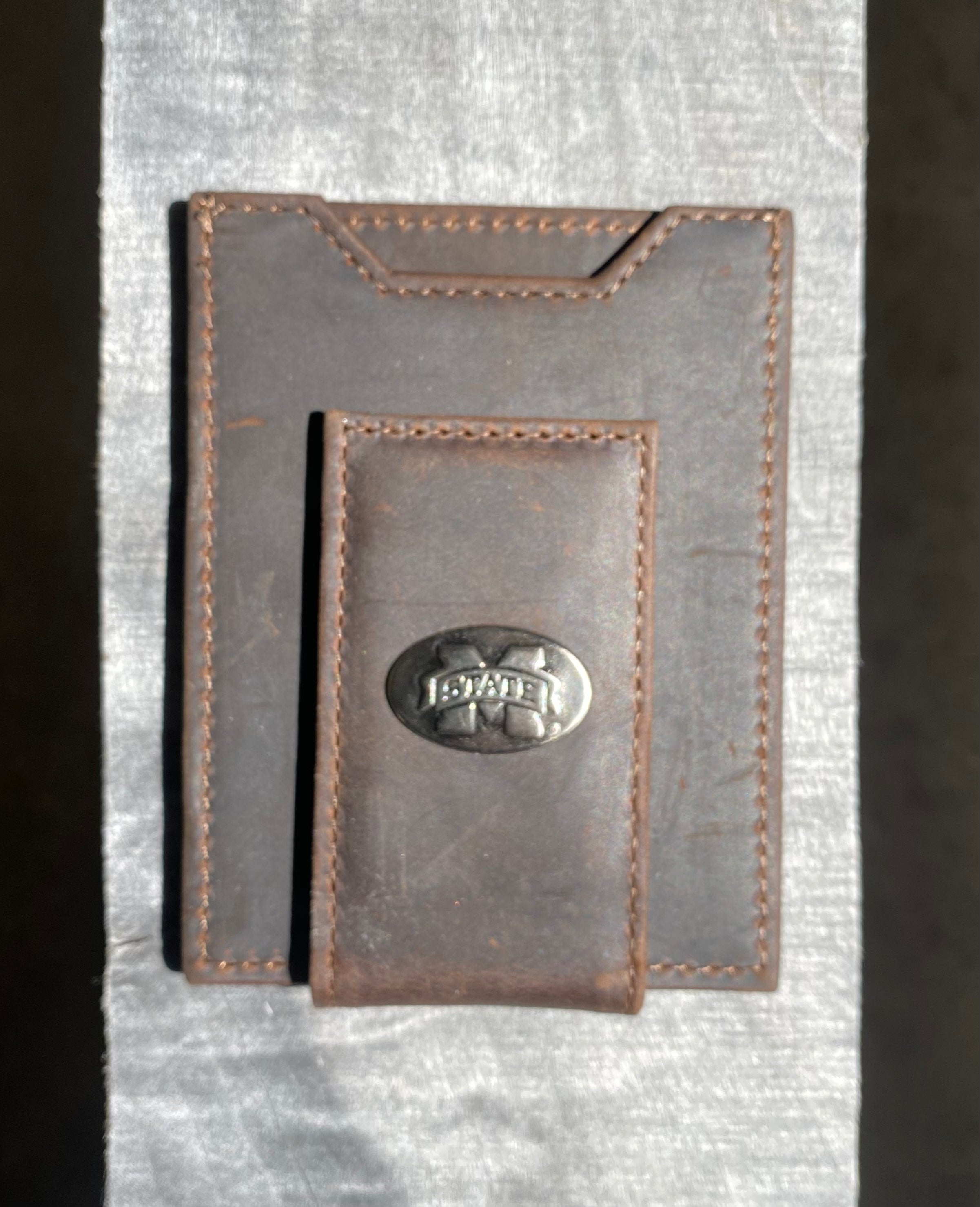 Zep Pro Mississippi State Brown “Crazy Horse” Leather Front Pocket Wallet with brass M State logo oval concho on bill closure tab. Front view.