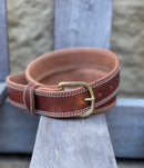 A brown oil-dipped leather belt with 2-row edging in white thread and a brass buckle. Front view.