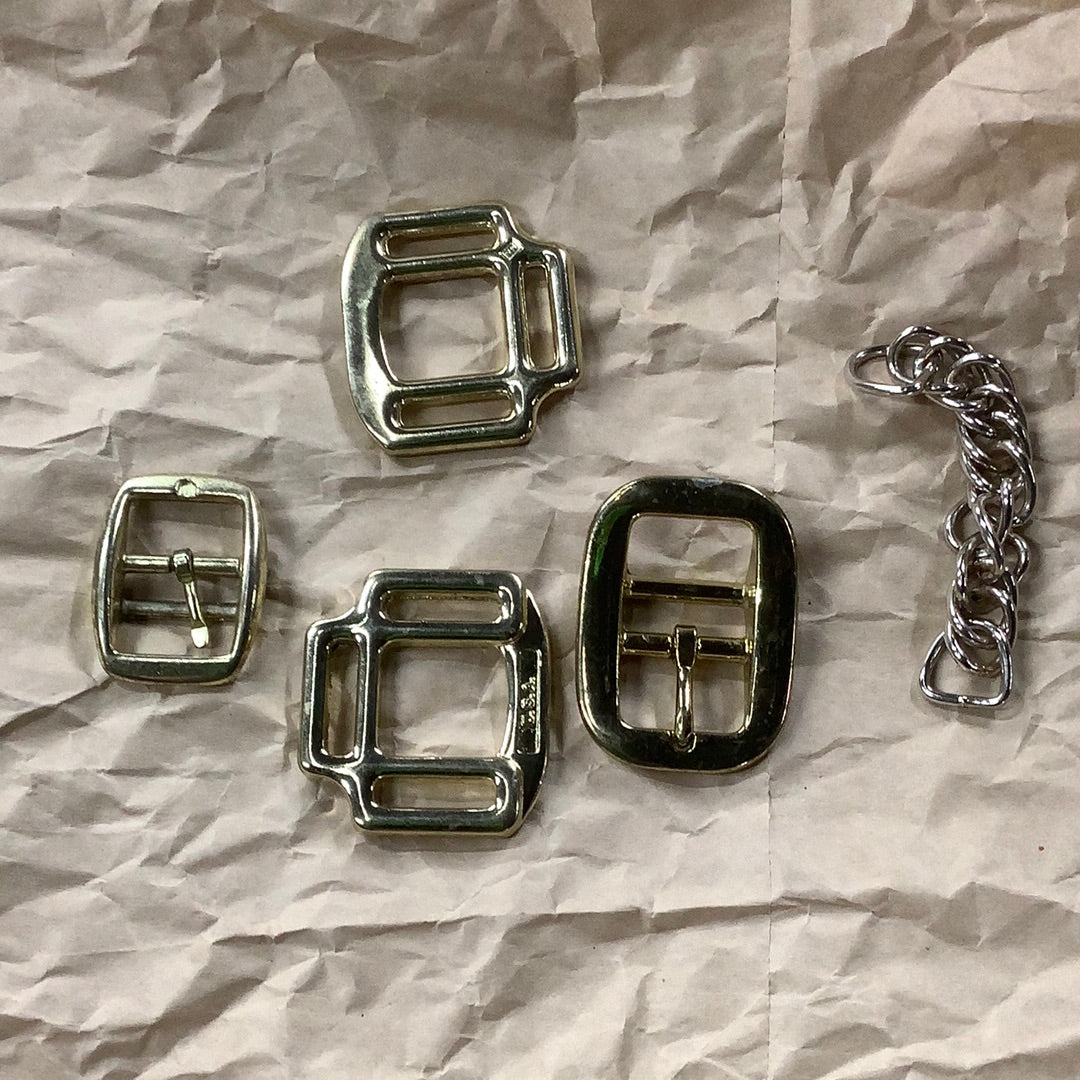 Assorted brass hardware pieces and buckles for use on a nylon halter. Also depicts a stainless steel flat interlocking curb chain. 