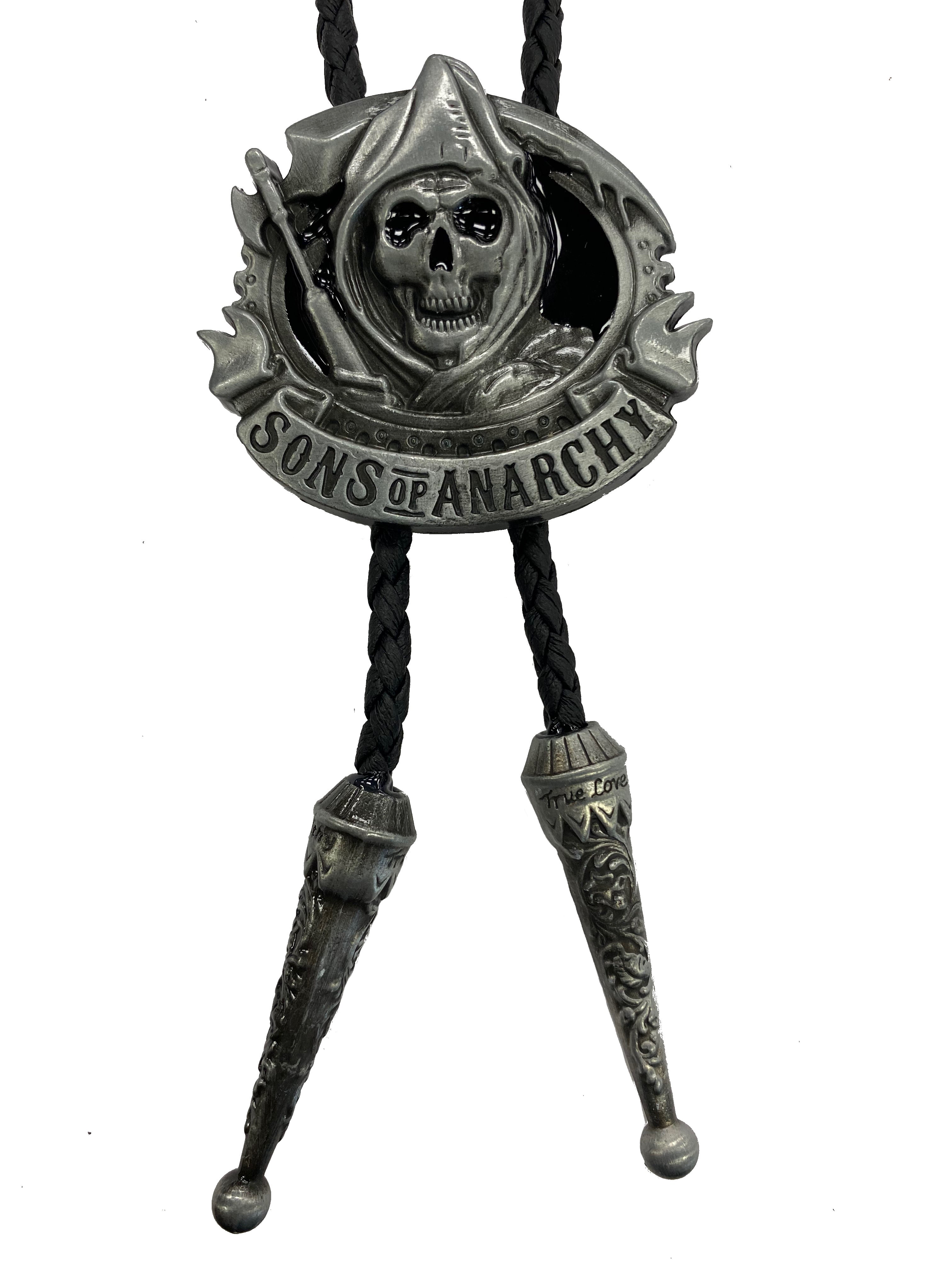 This Silver bolo tie features a hooded skull with Sons of Anarchy along the bottom. It has a Black braided cord with metal tips, and is fully adjustable.