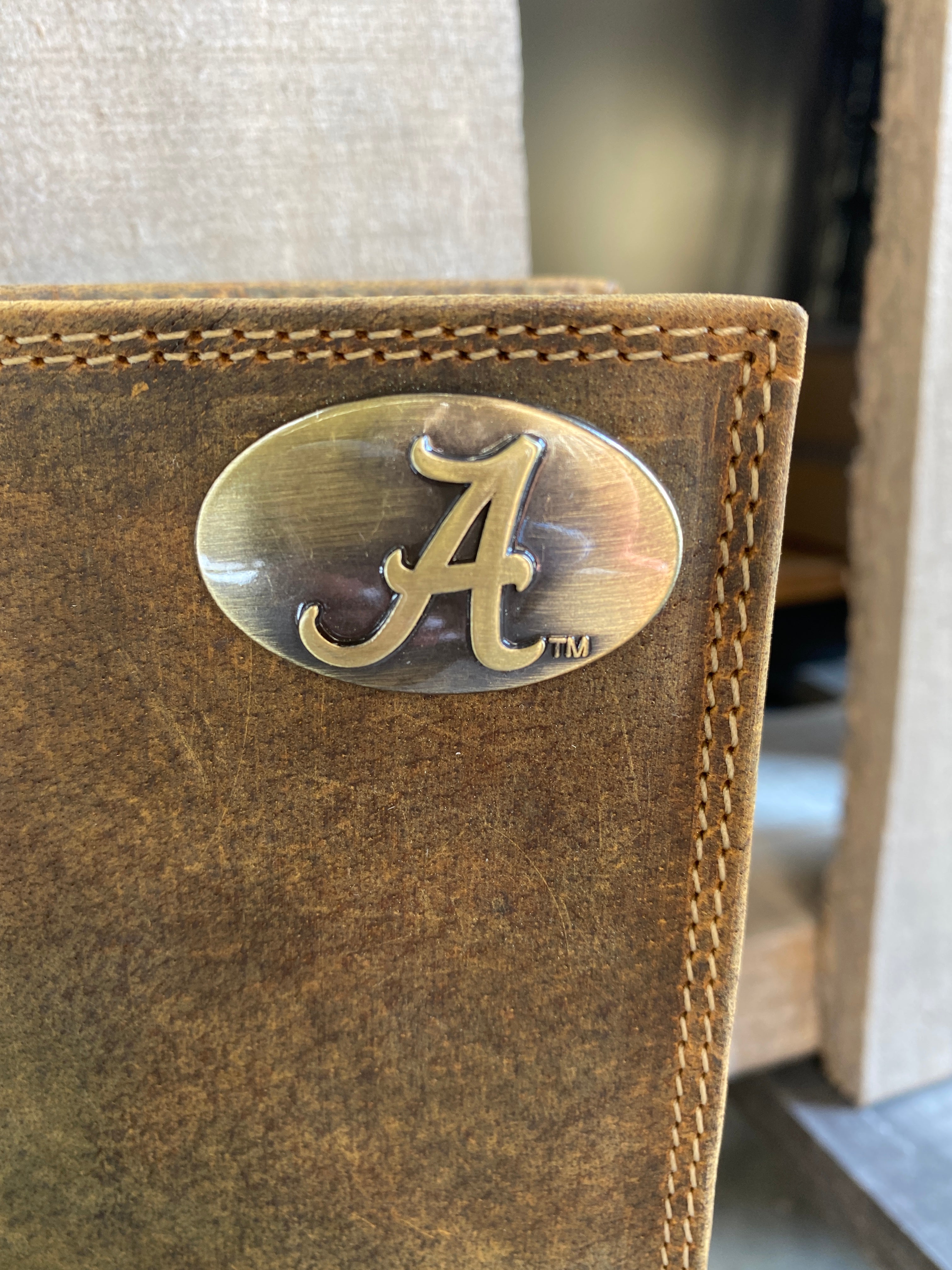 Zep Pro University of Alabama Roll Tide Vintage Tan Leather Tall Wallet front view shown features cloeup of brass Alabama logo "A" concho on top right.