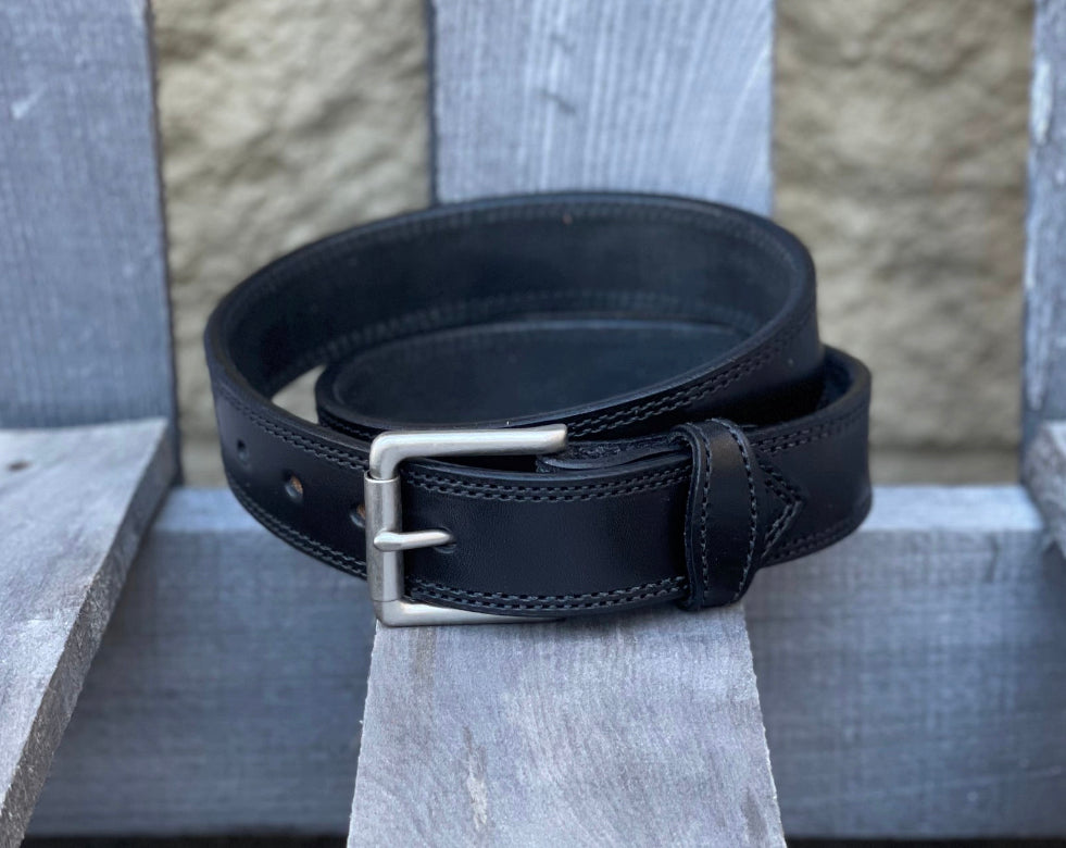 Black double stitched leather work belt with a nickel plated buckle. Front view.
